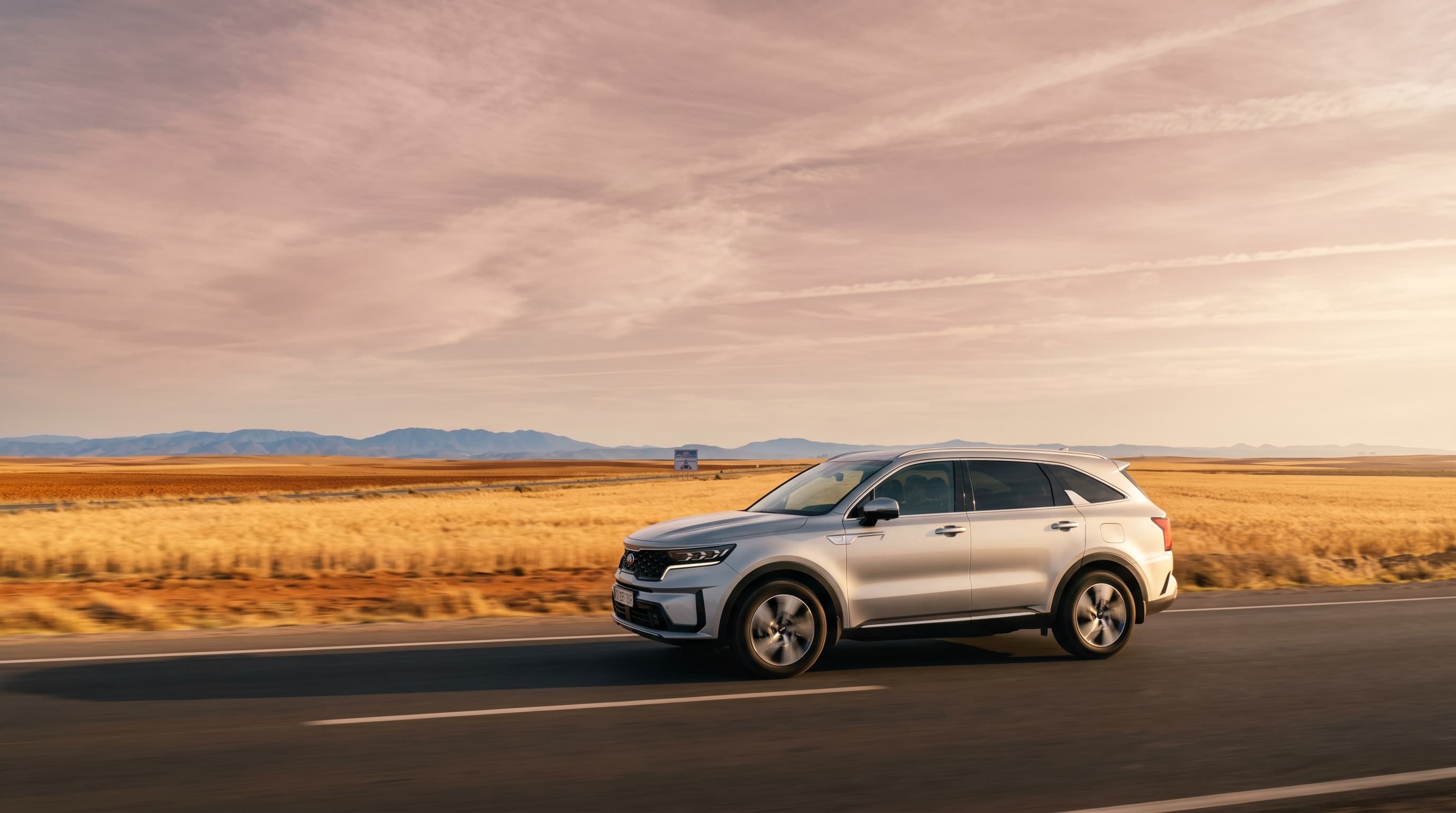 Marrakech to Casablanca private transfer — Kia Sorento on Moroccan highway through golden plains at sunset